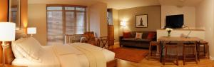 Sanctuary NYC Retreats في نيويورك: غرفة معيشة مع سرير وطاولة وأريكة