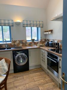 a kitchen with a washer and a washing machine at The Smiddy in Lochailort