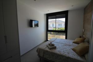 een slaapkamer met een groot bed en een raam bij Elvira Home San Gines AQ-104 in Santiago de la Ribera