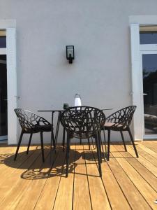 een zwarte tafel en twee stoelen op een houten vloer bij Vichy patrimoine mondial de l'Unesco in Bellerive-sur-Allier