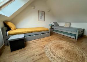 um pequeno quarto com 2 camas e um tapete em Maison de charme, proche plages em Saint-Pierre-Quiberon