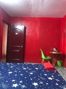 ein Schlafzimmer mit einem Bett und einer roten Wand in der Unterkunft The Big Boss Indian & Nepali Restaurant house in Sihanoukville