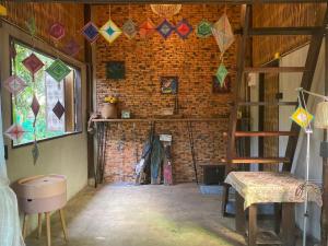 a room with colorful kites hanging from a brick wall at i AM i Farm Stay in Mē Tamān