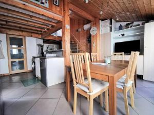 kuchnia i jadalnia z drewnianym stołem i krzesłami w obiekcie Résidence Village Merlin - Villa avec mezzanine pour 6 personnes - Port Leucate MAE-7804 w mieście Leucate