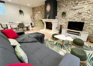 uma sala de estar com um sofá e uma lareira em Maison de charme, proche plages em Saint-Pierre-Quiberon