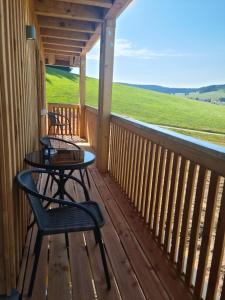 a porch with two chairs and a table on it at Ferienhaus Wendelhof in Eisenbach