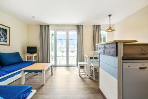 ein Wohnzimmer mit einem Sofa und einem Tisch in der Unterkunft Résidence Cap Azur - maeva Home - Appartement 3 Pièces 7 Personnes - Confor 80 in Fouesnant