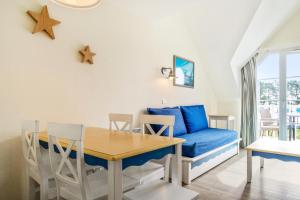 a living room with a blue couch and a table at Résidence Cap Azur - maeva Home - Appartement 2 Pièces 5 Personnes - Confort MAE-4387 in Fouesnant +7 photos