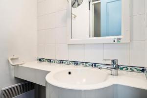 a white bathroom with a sink and a mirror at Résidence Cap Azur - maeva Home - Appartement 2 Pièces 5 Personnes - Confort MAE-4387 in Fouesnant