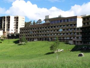 a building with a grassy field in front of a building at Résidence Les Glovettes - Studio pour 4 Personnes 134 in Villard-de-Lans