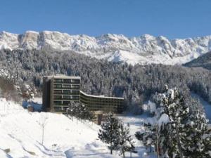 a building on top of a snow covered mountain at Résidence Les Glovettes - Studio pour 4 Personnes 134 in Villard-de-Lans
