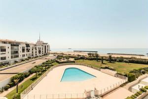 a view of a swimming pool and the ocean at Résidence Les Rivages de Rochelongue - maeva Home - Appartement 3 pièces 6 11 in Cap d'Agde