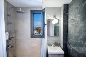 a bathroom with a sink and a shower with a window at E&A luxury apartment with sea view in Rhodes Town +47 photos