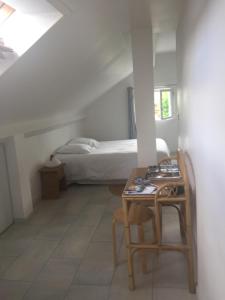 a room with a bed and a table and chairs at Vichy patrimoine mondial de l'Unesco in Bellerive-sur-Allier