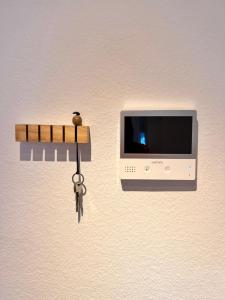 Ein Haufen Schlüssel hängt an einer Wand neben einem Fernseher in der Unterkunft FewoReNo in Recklinghausen