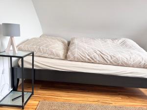 ein Bett mit einem schwarzen Rahmen und einer weißen Bettdecke in der Unterkunft FewoReNo in Recklinghausen