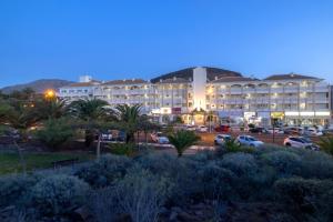 a large building with cars parked in a parking lot at whala!tenerife in Playa de las Americas