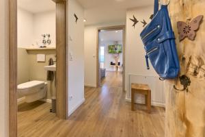 a bathroom with a toilet and a bag on the door at Ferienhaus Wendelhof in Eisenbach