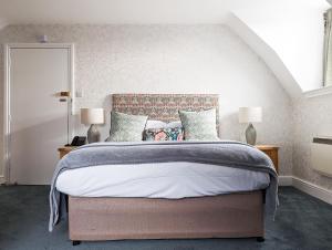 a bedroom with a large bed with two lamps at Three Salmons Hotel in Usk