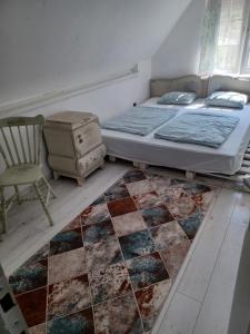 sypialnia z łóżkiem, krzesłem i dywanem w obiekcie Kinga w Siófoku