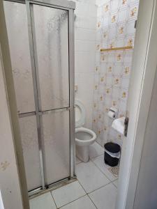 a bathroom with a toilet and a glass shower stall at Grande Hotel Torres in Torres