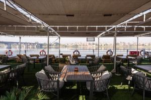 un restaurante con mesas y sillas y vistas al agua en Magic I Nile Cruise Deluxe Boat The scheduled departure is on Saturday for a 7-day Nile cruise en Luxor