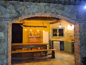 een keuken met een houten tafel in een stenen muur bij MAISON DE CARACTERE AVEC PISCINE in Sartène