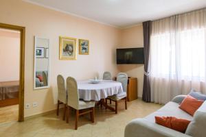 - un salon avec une table, des chaises et un canapé dans l'établissement Vila Curic, à Dubrovnik