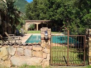 un cancello per una piscina con recinzione in pietra di MAISON DE CARACTERE AVEC PISCINE a Sartène