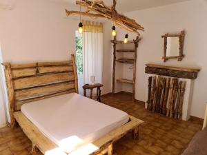 a bedroom with a wooden bed and a fireplace at MAISON DE CARACTERE AVEC PISCINE in Sartène