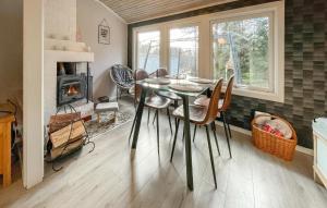 a dining room with a table and a fireplace at Lovely Home In Lnghem With Kitchen in Länghem
