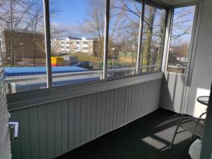 Habitación con ventanas y vistas a la piscina. en Privat apartment Bojan, en Malmö