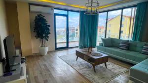 sala de estar con sofá verde y ventana grande en Luxury Duplex With Wonderful View In Izmit, en Çavuşçiftliği