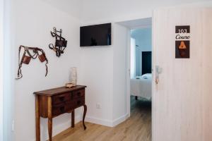 um quarto com uma mesa e uma televisão na parede em Quinta do Louredo - Évora em Évora