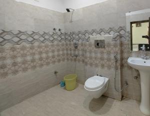 een badkamer met een douche, een toilet en een wastafel bij Hotel GENEXT in Lucknow
