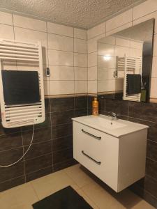 uma casa de banho com um lavatório e um espelho em Chambre climatisée et cosy Auberge du manala Hôtel 24 24 em Saint-Louis
