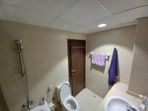 a bathroom with a toilet and a sink and a shower at Fully furnished studio apartment in Ajman 