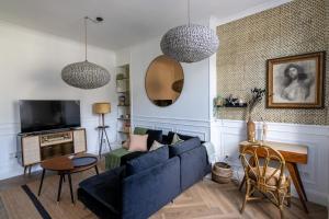 a living room with a blue couch and a table at Le Duplex d'Eugenie - Parking - Centre - Clim in Saumur