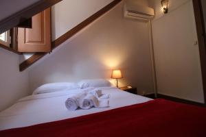 a bedroom with a bed with towels on it at Casas da Biquinha in Sintra