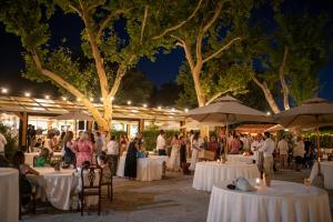 een groep mensen die 's nachts rond tafels staan bij Quinta do Louredo - Évora in Évora