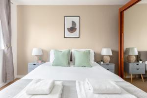 a bedroom with a large white bed with green pillows at The Canonbury Villa in London