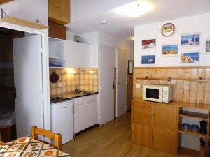 a kitchen with white cabinets and a microwave at Résidence Combettes - 2 Pièces pour 4 Personnes 624 in Les Contamines-Montjoie