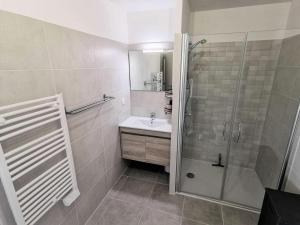 a white bathroom with a shower and a sink at Résidence Les Voiles Blanches - 2 Pièces pour 4 Personnes 854 in Leucate