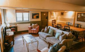 ein Wohnzimmer mit einem Sofa und einem Tisch in der Unterkunft Meadow Cottage in Wimborne Minster