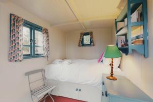 ein Schlafzimmer mit einem Bett und einem Schreibtisch mit einer Lampe in der Unterkunft Meadow Cottage in Wimborne Minster