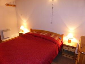 a bedroom with a red bed and two lamps on tables at Résidence L'enclave - 3 Pièces pour 6 Personnes 744 in Les Contamines-Montjoie