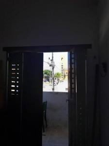 a dark room with an open door with a view of a street at Casa Charmosa Verde-Azul in Paracuru
