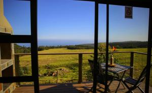 un tavolo e sedie su una veranda con vista sull'oceano di Down-to-Earth Luxury Tented Accommodation a George