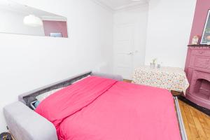 ein Schlafzimmer mit einem rosa Bett und einem Tisch in der Unterkunft Charming Bright Apt In Paris in Paris