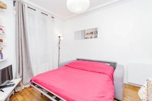 ein Schlafzimmer mit einem Bett mit einer rosa Decke in der Unterkunft Charming Bright Apt In Paris in Paris